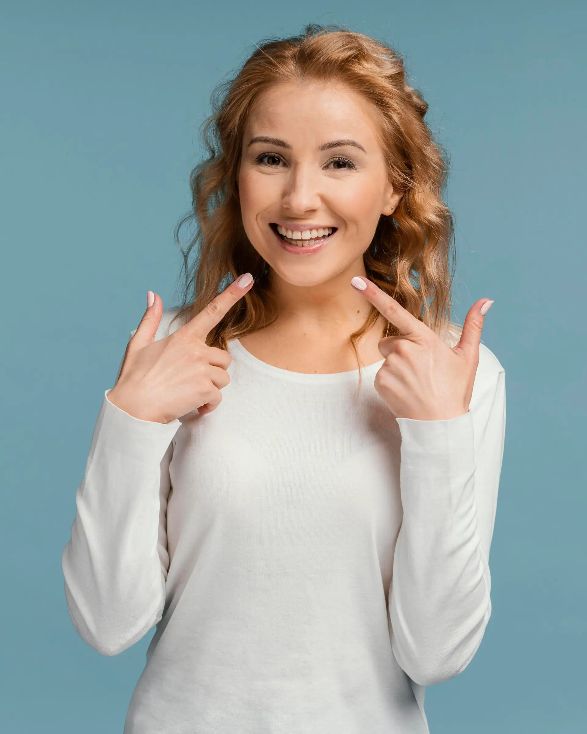 śmiejąca się-kobieta-wskazująca-usta-implant dentystyczny